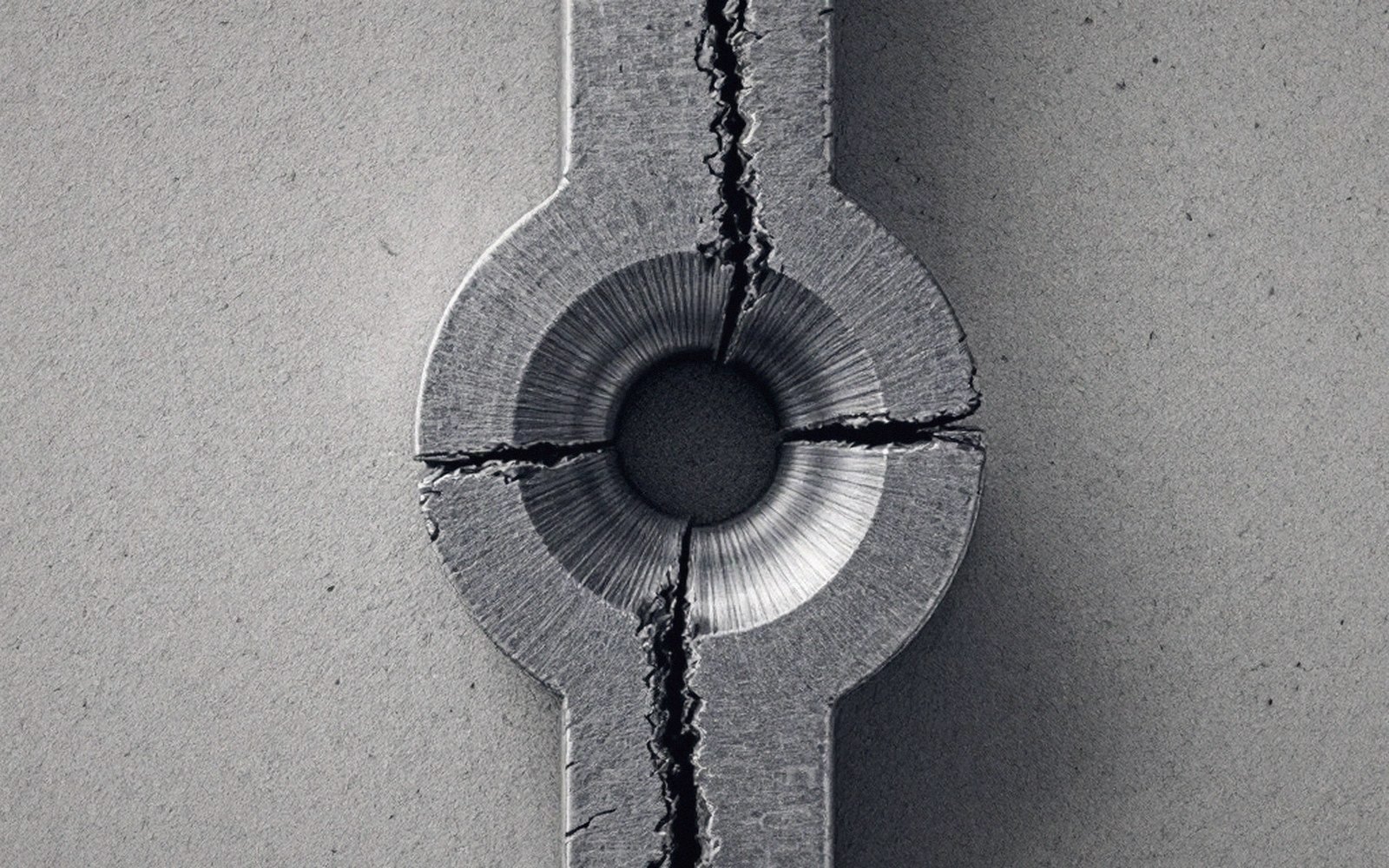 Cracked metal specimen fractured through a central hole after tensile testing
